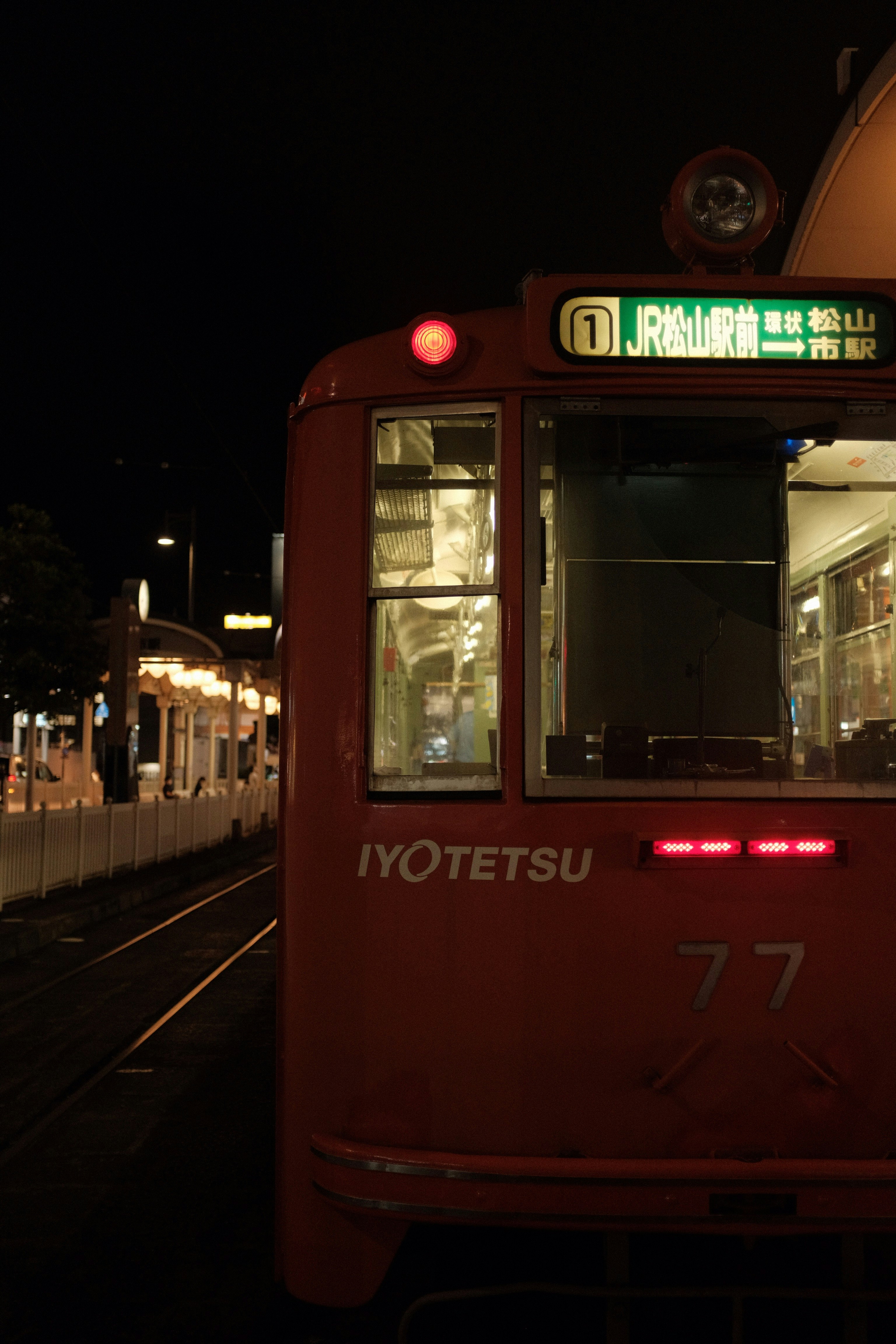 red and white train on the street during night time